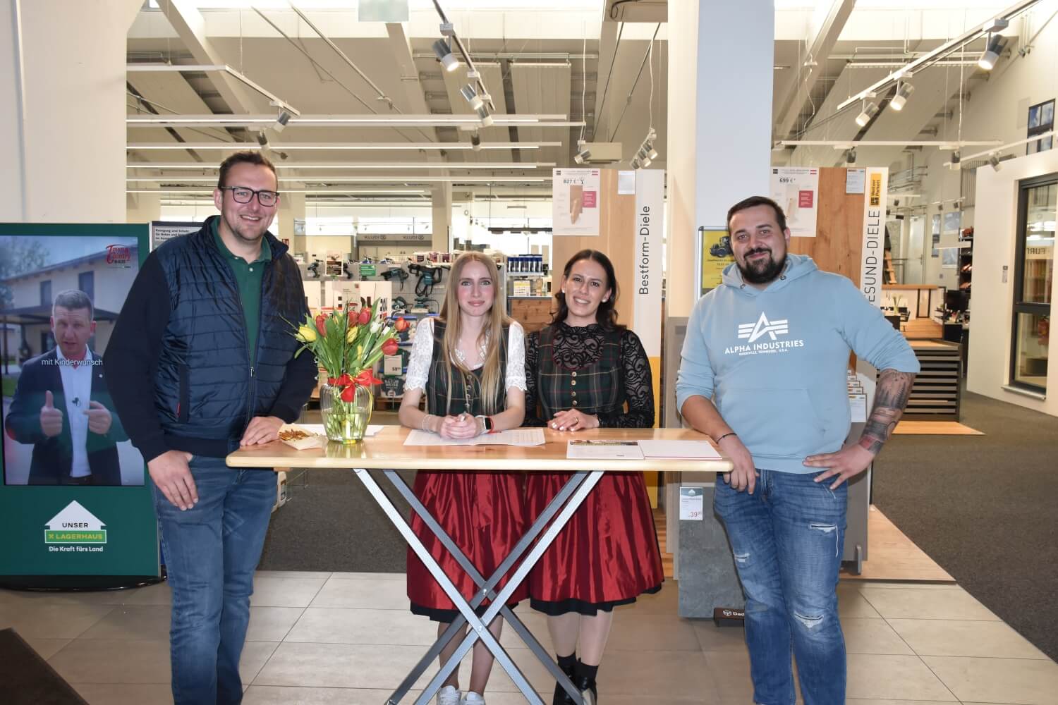 Bauinfo Abend Town&Country Bauinfo Abend. 4 Personen stehen an einem Tisch im Baustoffverkaufsraum Klagenfurt Südring